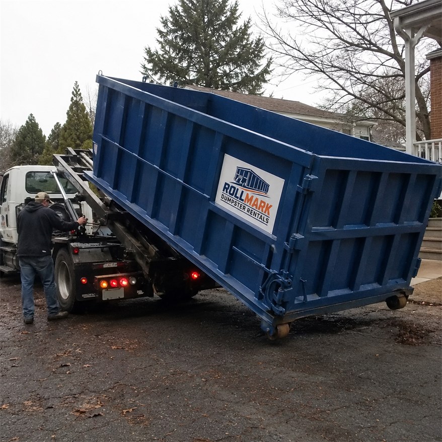 Rollmark dumpster rental team equipment near a roll-off dumpster truck
